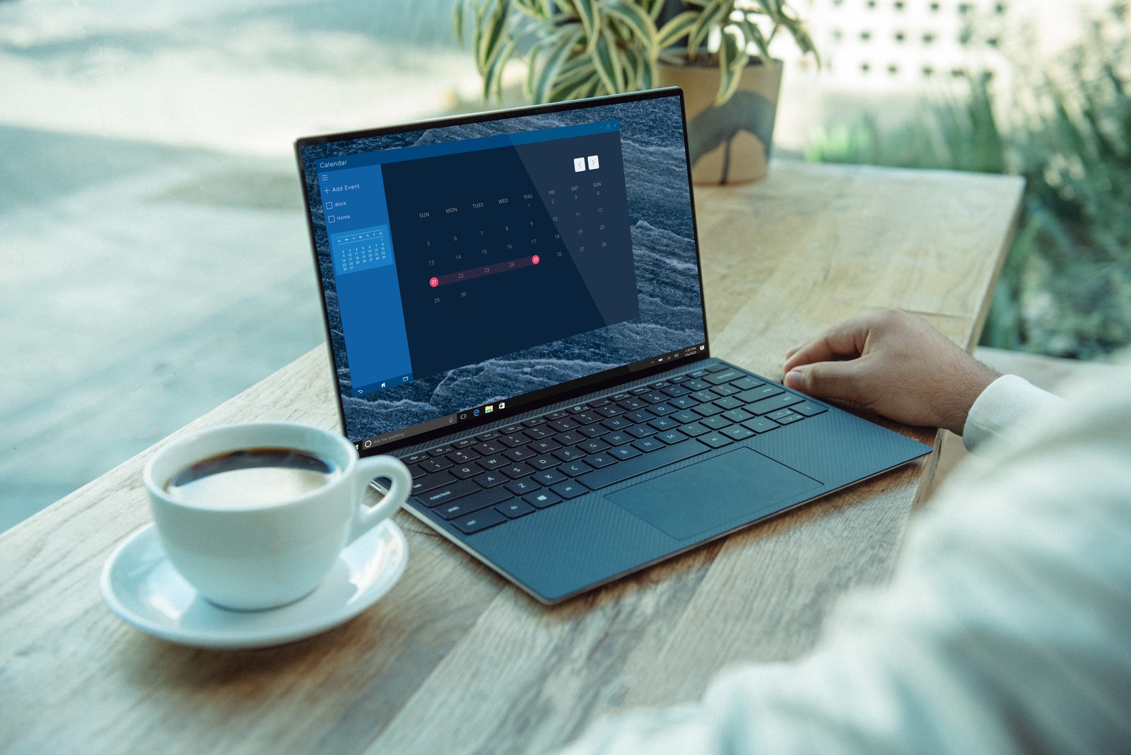 Photo par XPS person using black laptop computer on brown wooden table